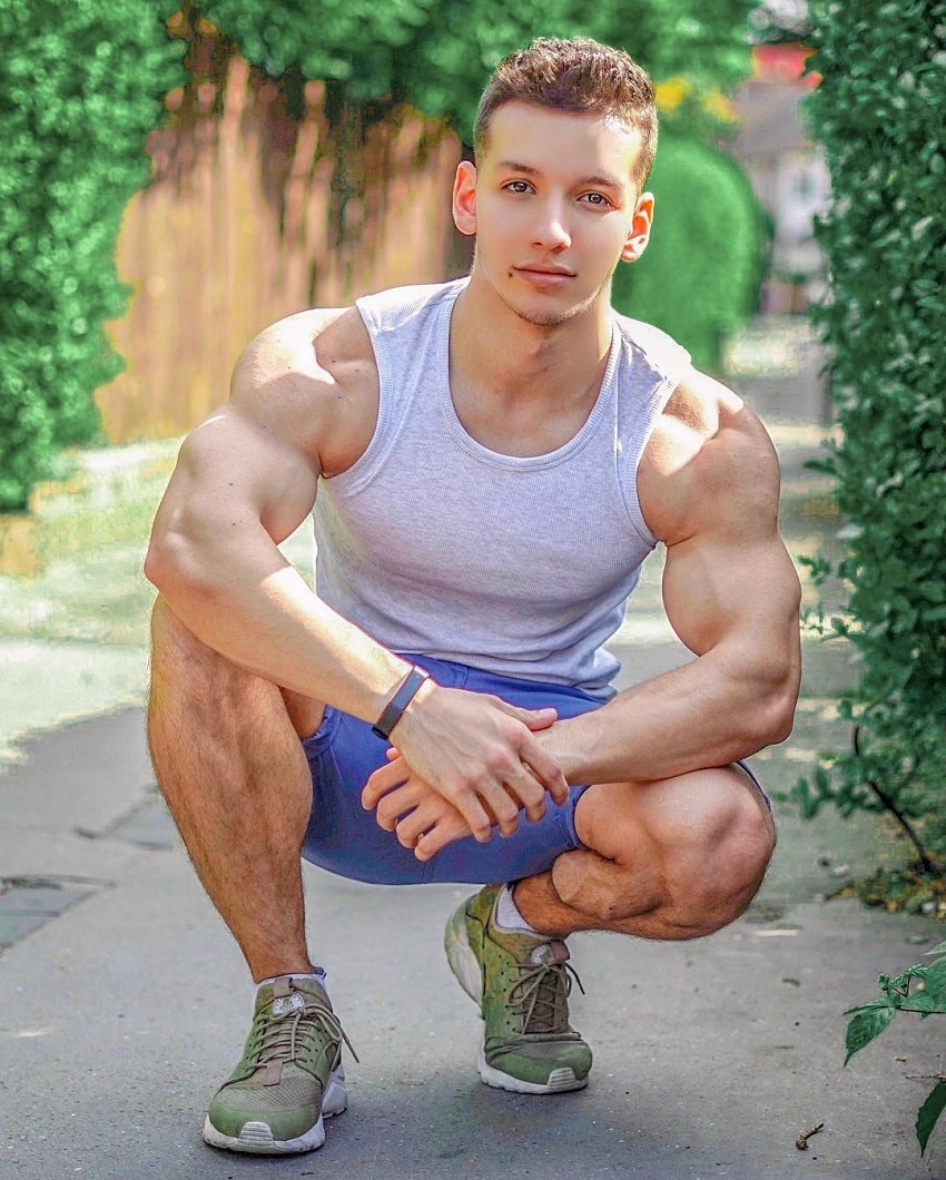 Radoslav Raychev crouching, showing off his remarkable physique in a grey tank top