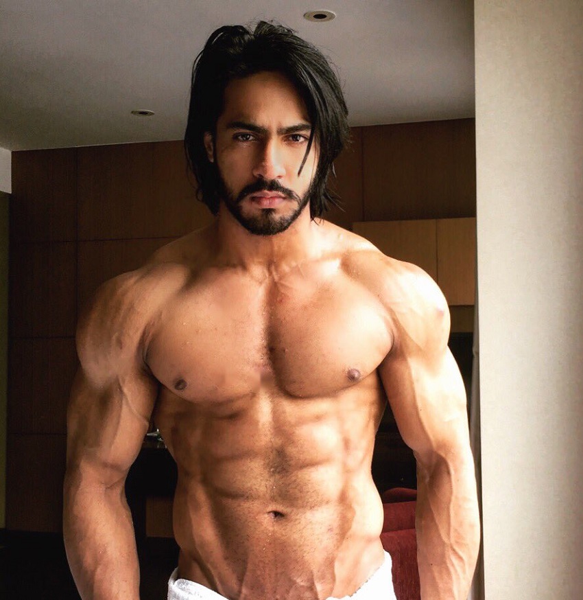 Thakur Anoop Singh posing shirtless with a towel around his belt looking strong and ripped