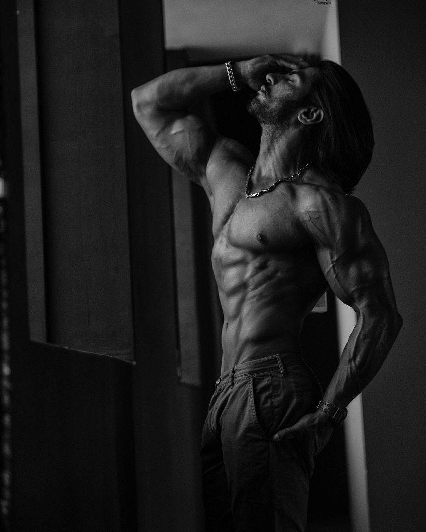 Thakur Anoop Singh posing shirtless in a white and black photo looking ripped