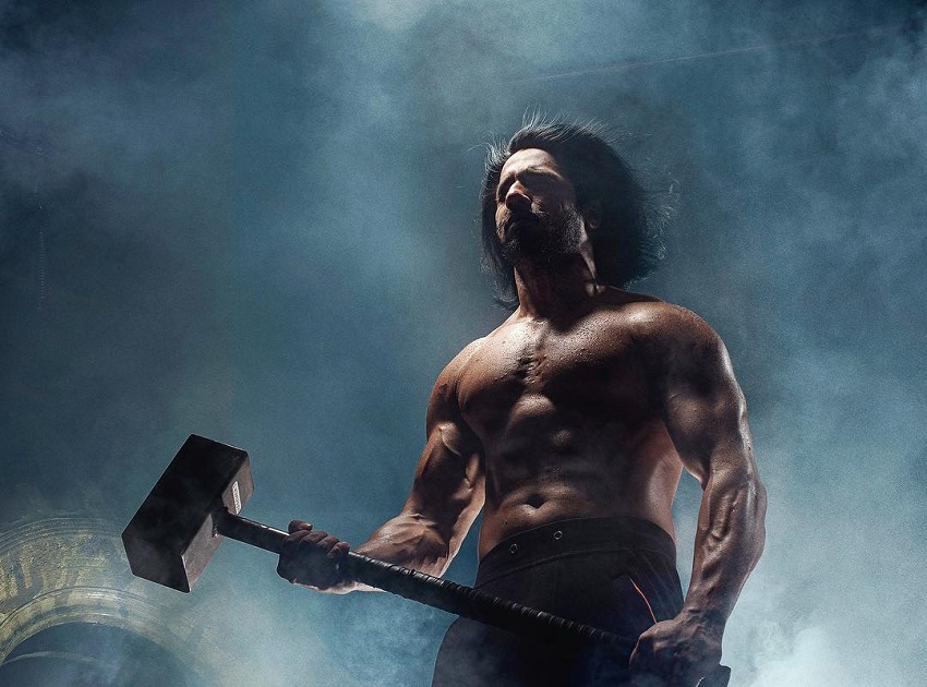 Thakur Anoop Singh posing with a sledgehammer in his hands looking strong and fit