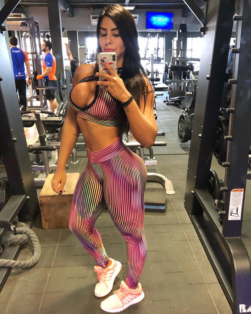 Amanda Choairy taking a picture of herself in leggings in a gym