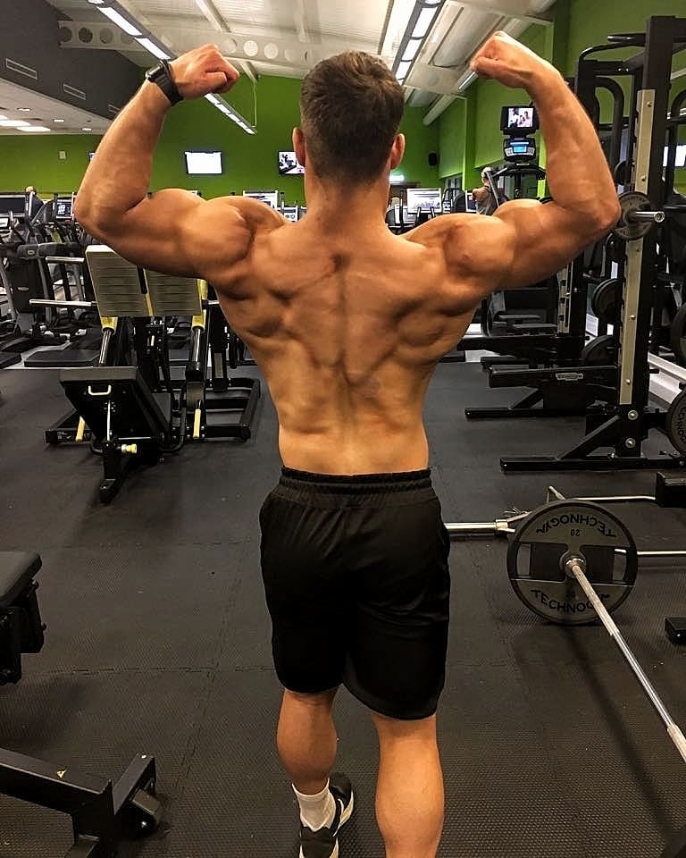 Dan Tai doing a shirtless back double biceps pose