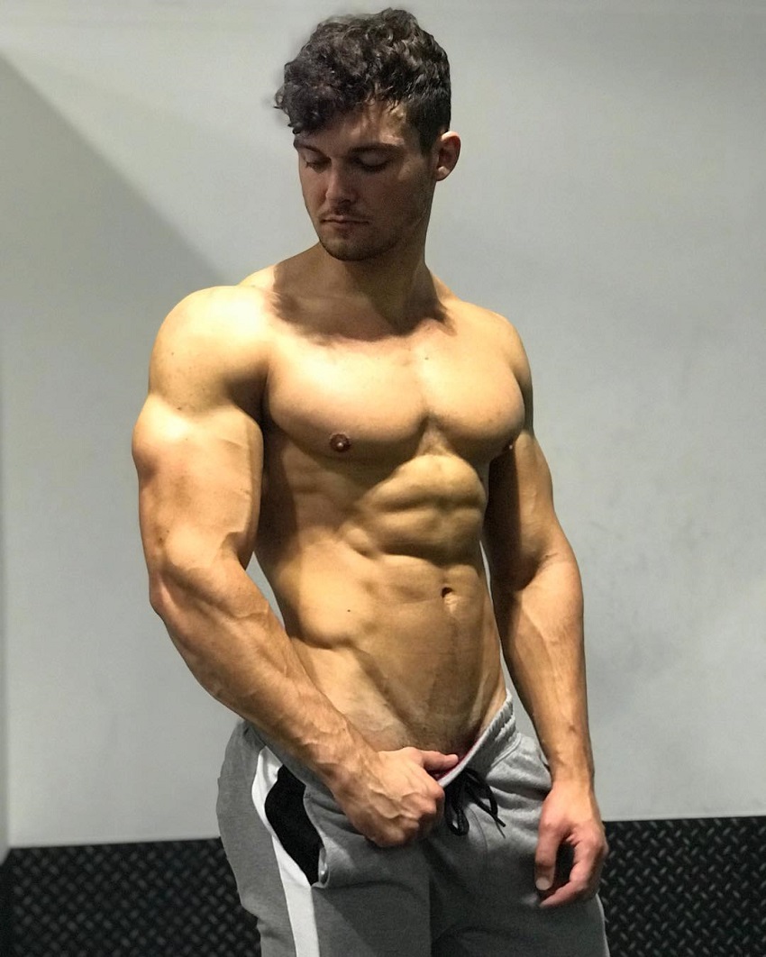 Josh Watson posing shirtless for a photo looking muscular and ripped