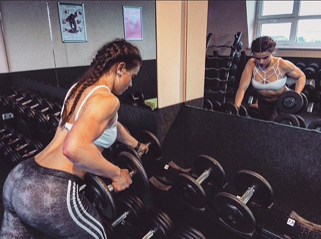 Leonie Stern training hard with dumbbells in the gym