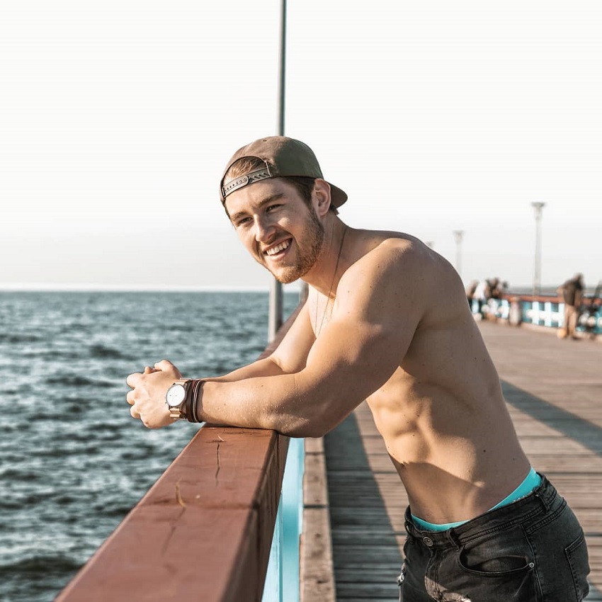 Matt Lucas standing shirtless on a pier looking fit