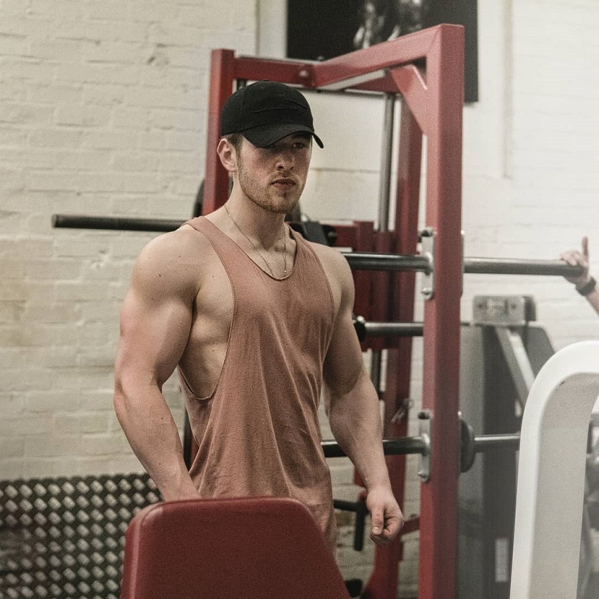 Matt Lucas posing in a gym in his tank top looking muscular