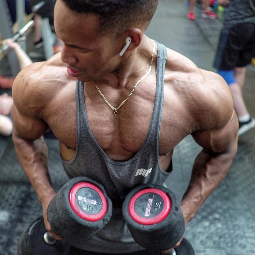 Mike Diamonds training with dumbbells in a gym looking ripped