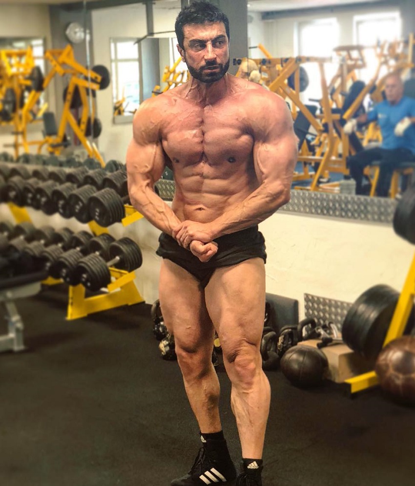 Murat Demir flexing his strong and ripped muscles in a gym