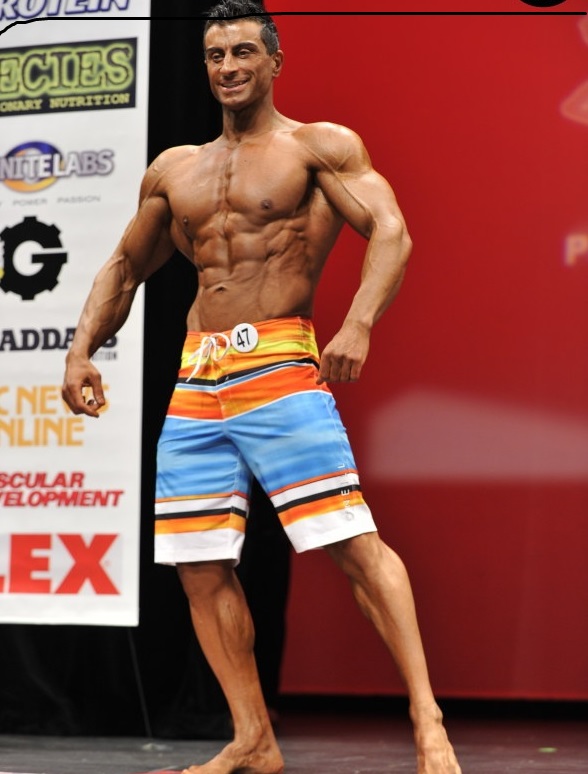 Murat Demir posing on a bodybuilding stage