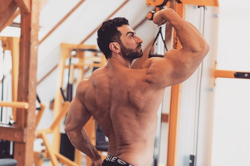 Murat Demir flexing his arms and back