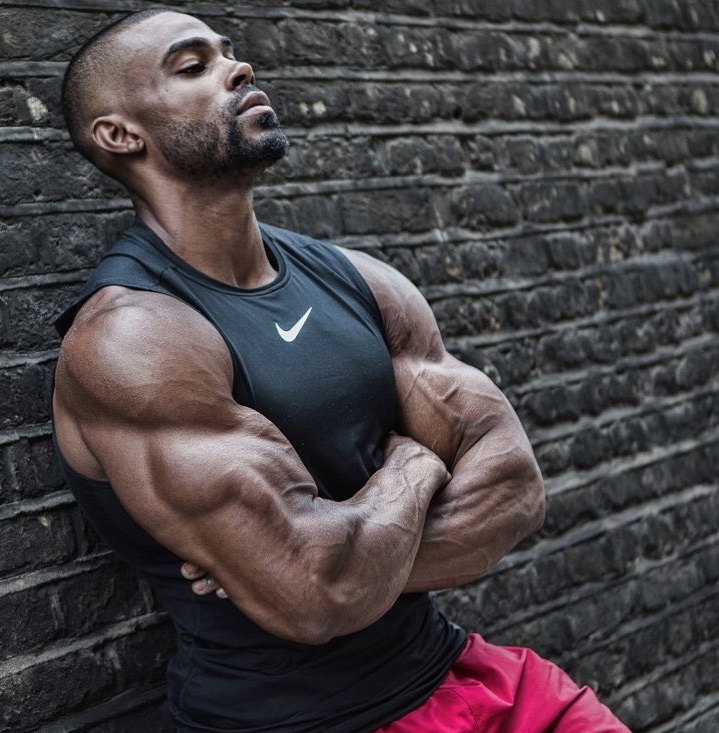 Nathan Williams leaning against a wall looking strong and ripped