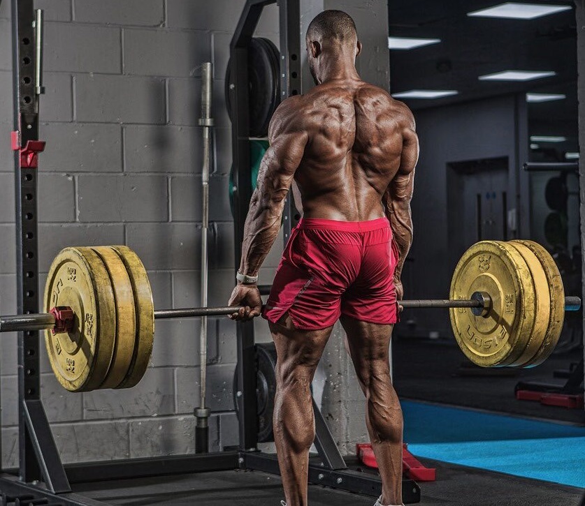 Nathan Williams lifting an extremely heavy barbell loaded with weights looking strong and rpped