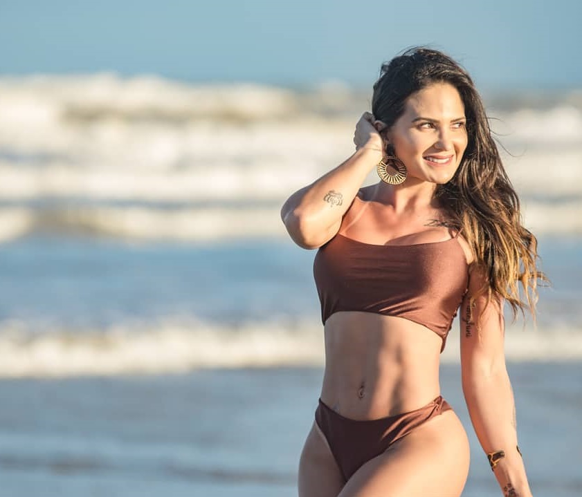 Sol Meneghini posing on the beach smiling and looking fit