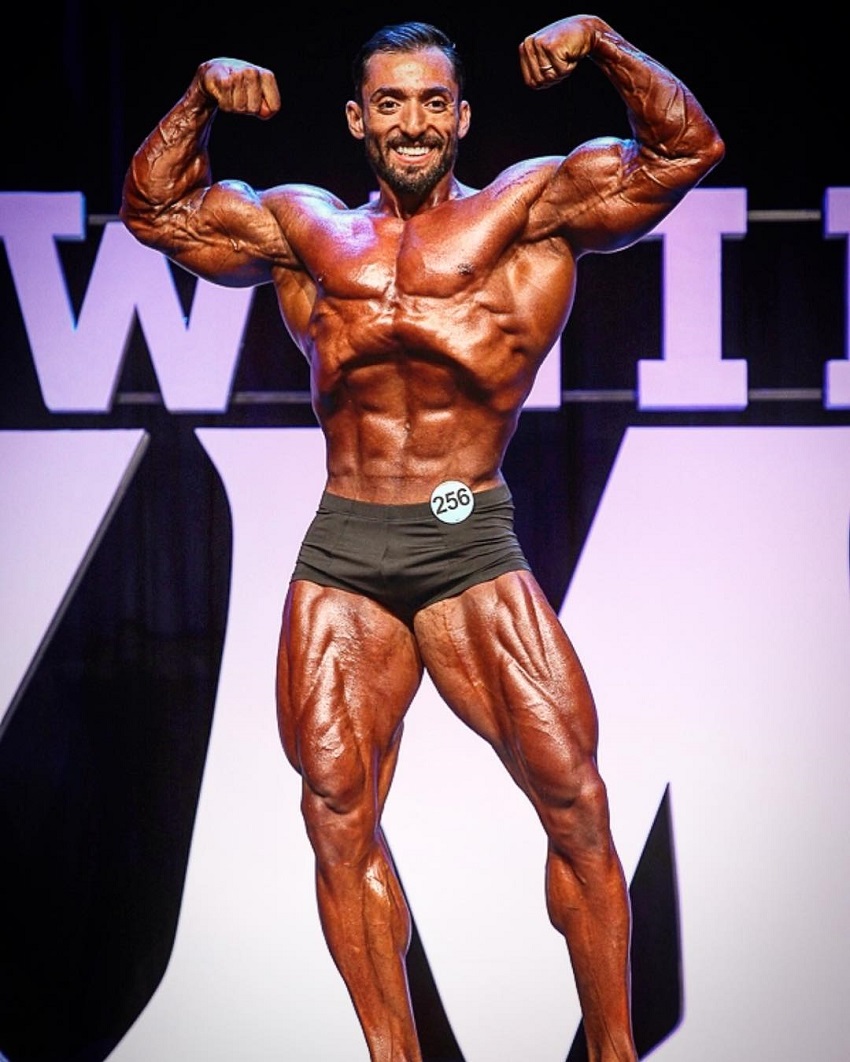 Abtin Shekarabi performing a front double biceps pose on the Joe Weider's Mr. Olympia stage 2018 Las Vegas