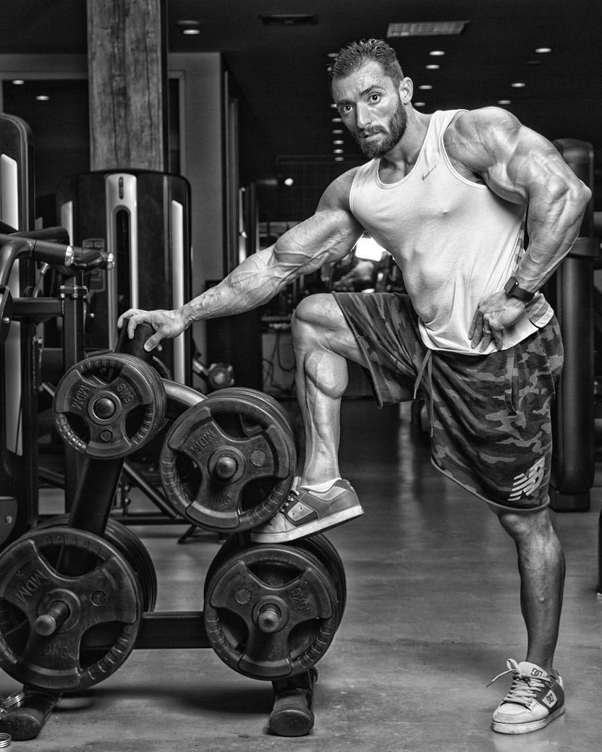 Abtin Shekarabi leaning against weight plates during a photo shoot