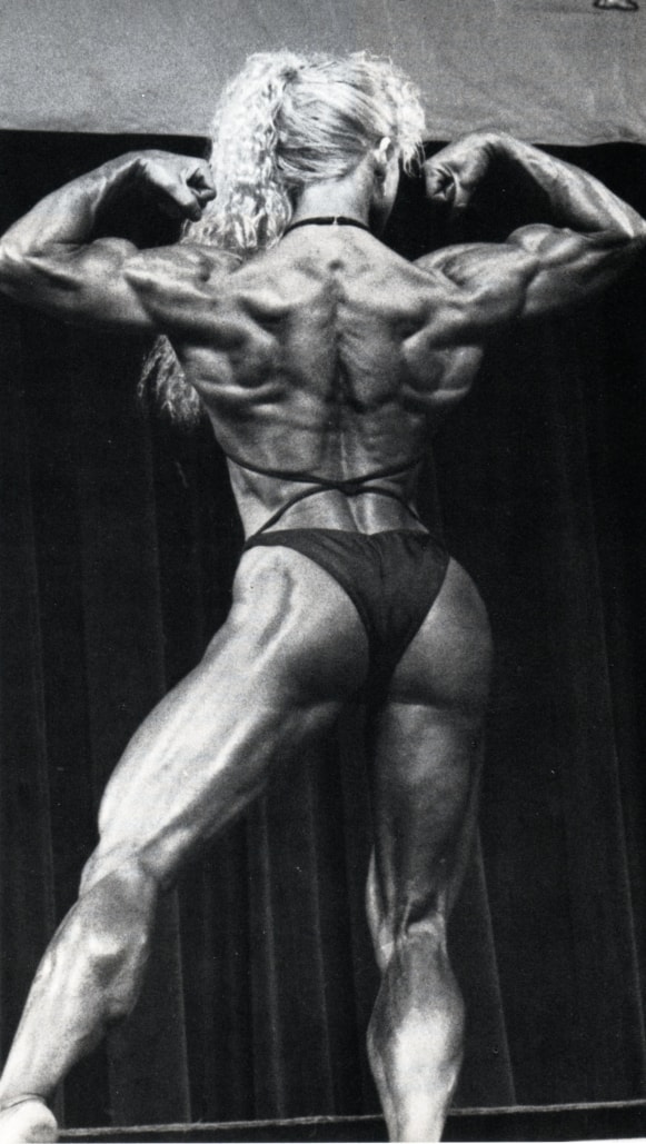 Ellen van Maris doing a back double biceps flex on the bodybuilding stage