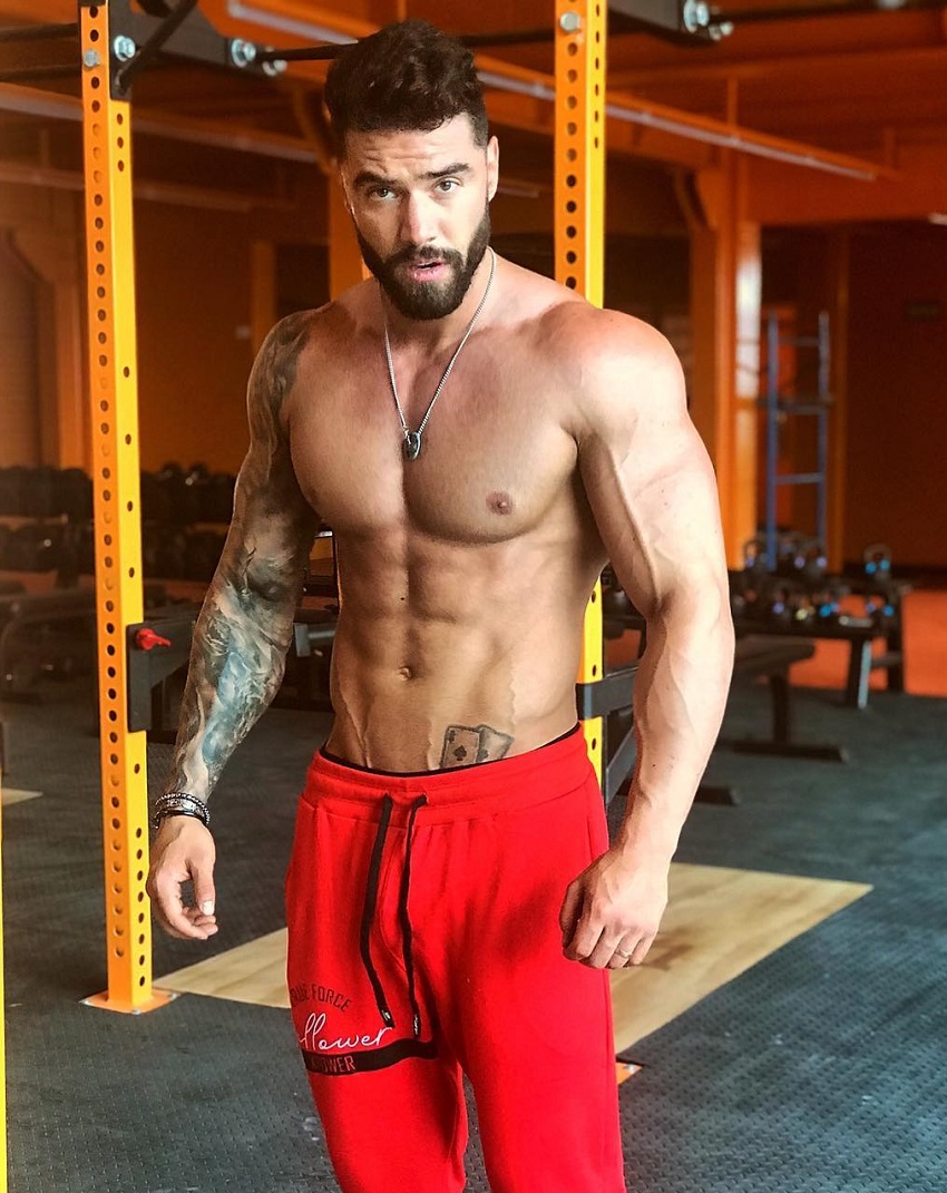 Fernando Lozada Zuniga standing shirtless in his red shorts, looking ripped