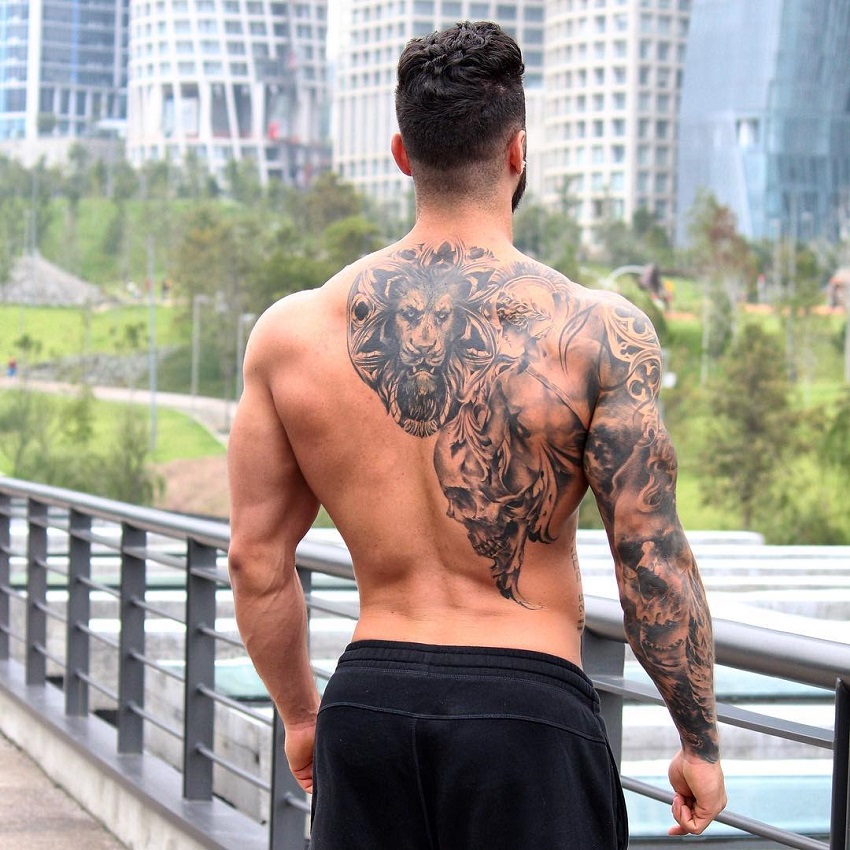 Fernando Lozada Zuniga posing shirtless on a bridge, his tattooed back looking riped and muscular
