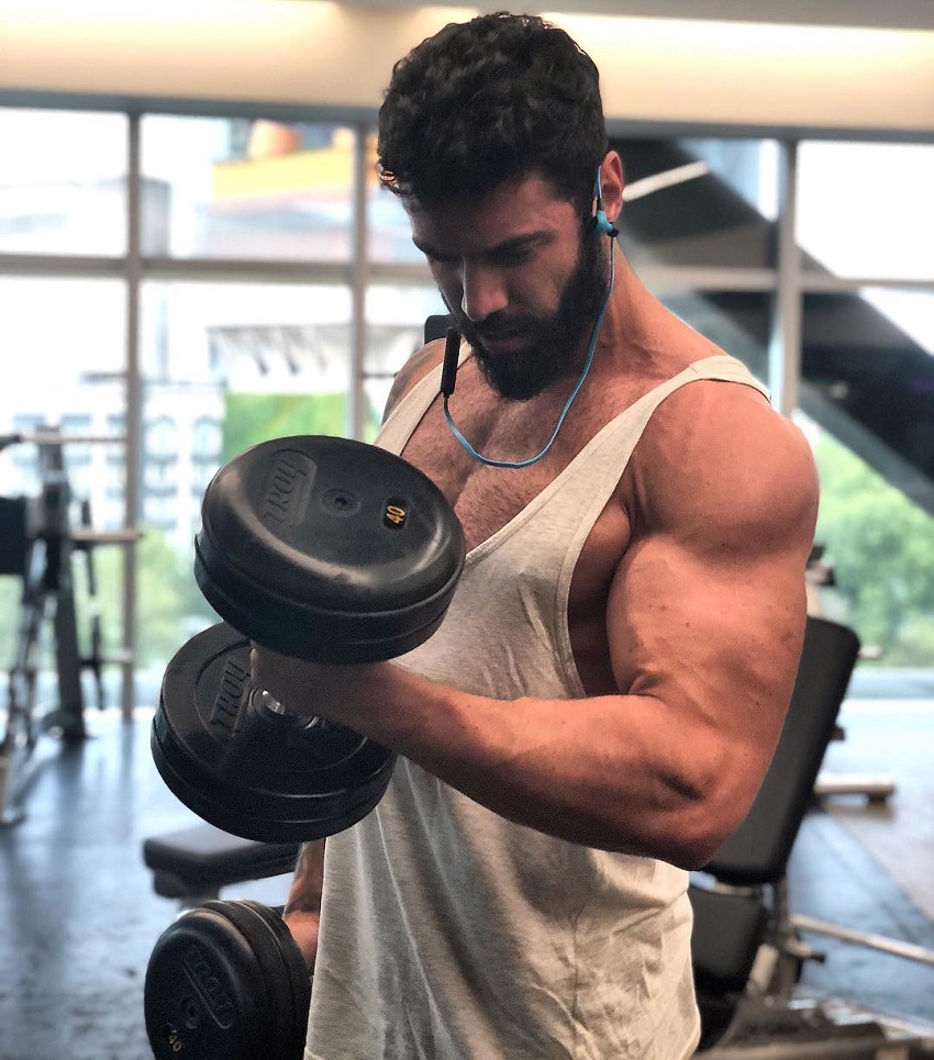 Fernando Lozada Zuniga performing heavy biceps curls in a gym