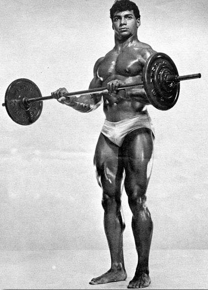 Harold Poole doing barbell biceps curls shirtless