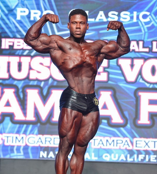 Keone Pearson doing a front double biceps pose on the classic bodybuilding stage