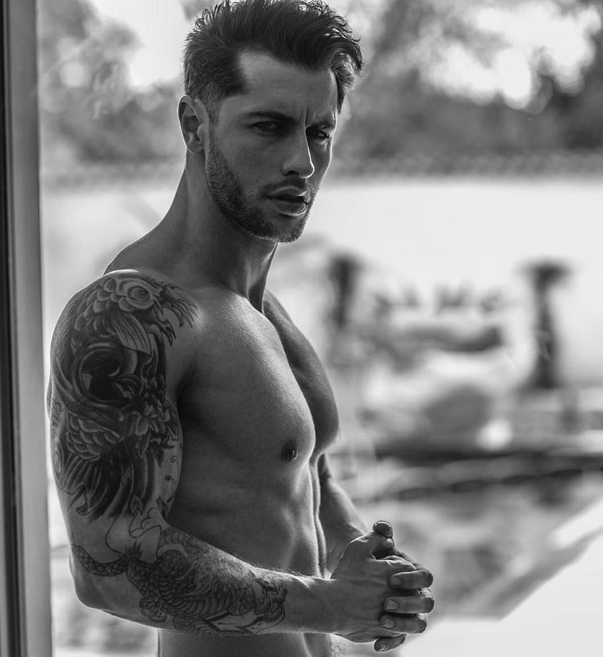 Vince Azzopardi standing shirtless on a balcony looking strong and fit