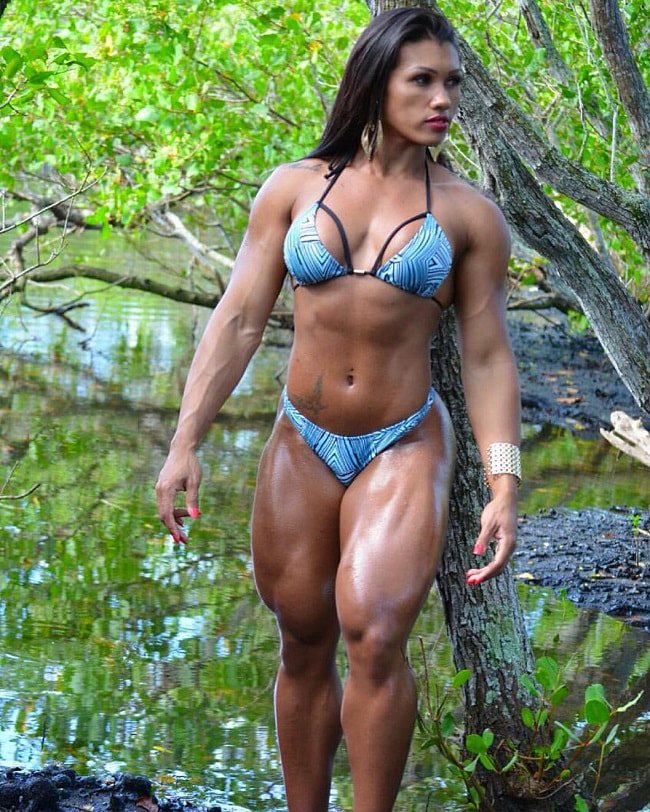 Alessandra Alvez Lima posing outdoors in a jungle, looking fit and lean in her green bikini