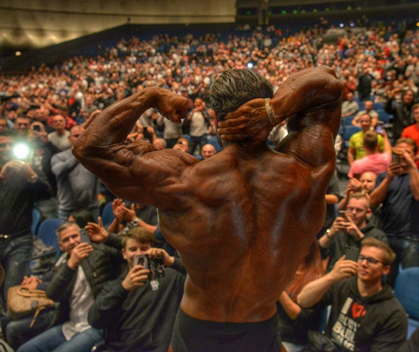 David Hoffmann flexing shirtless in front of a huge crowd