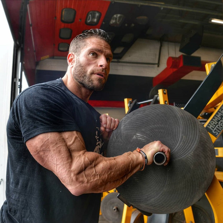 David Hoffmann resting on a machine in gym, his triceps looking huge and vascular