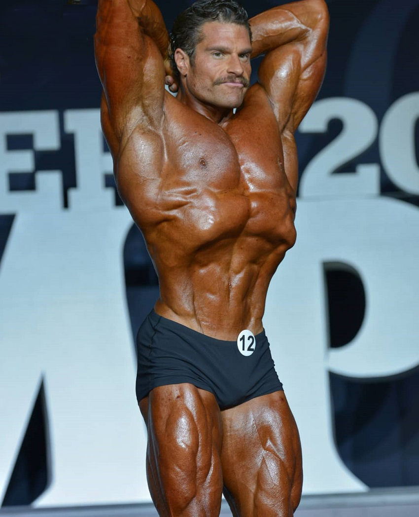 David Hoffmann doing a most muscular pose on the bodybuilding stage