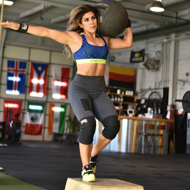 Heba Ali training with a medicine ball in a big warehouse