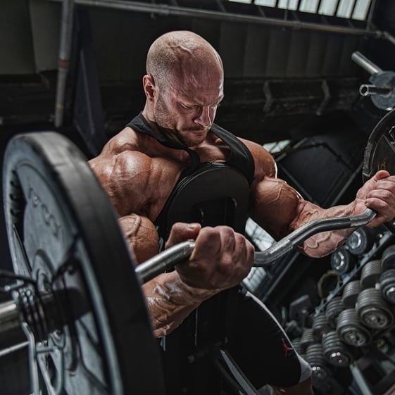 James Hollingshead doing heavy biceps curls in the gym