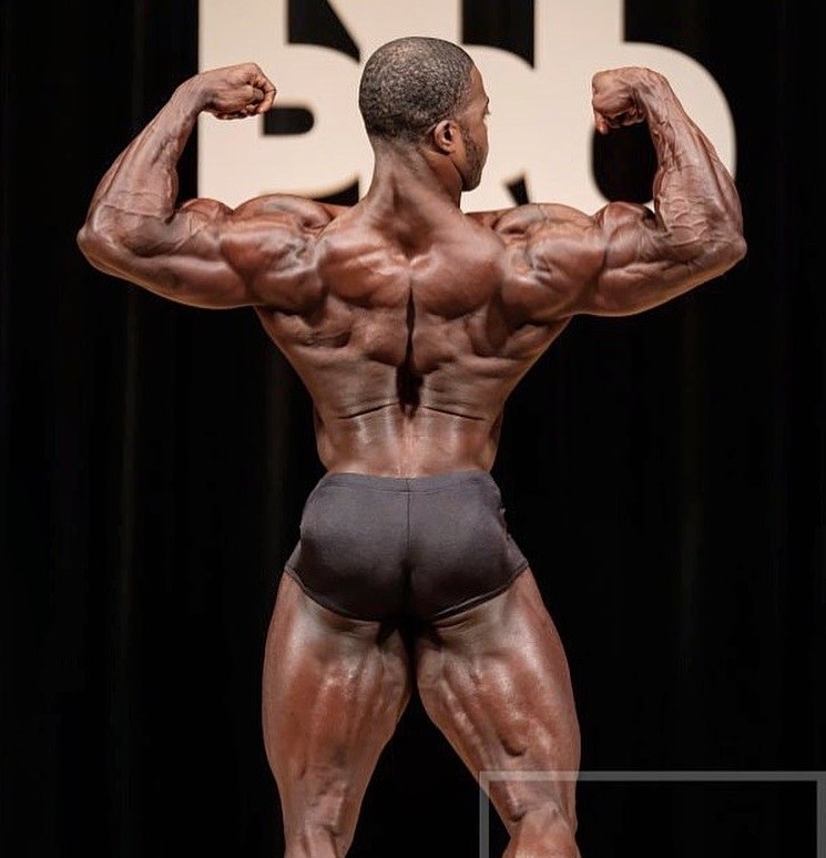 Kenneth Owens performing a back double biceps pose looking big and ripped