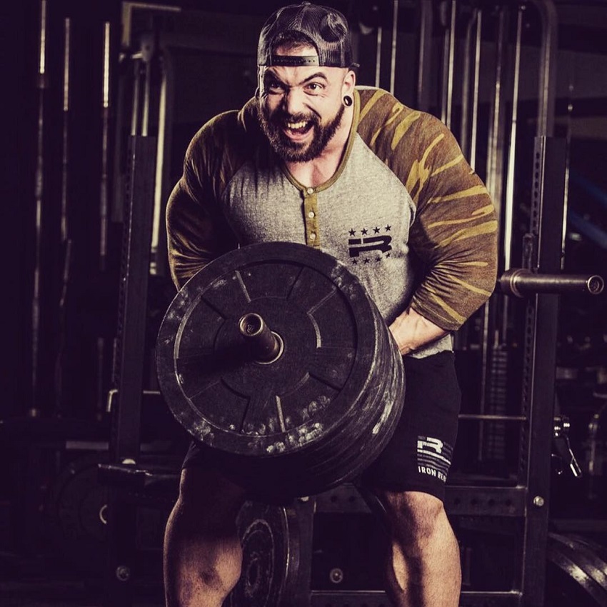 Luke Sandoe doing heavy T-bar rows with a pained expression on his face