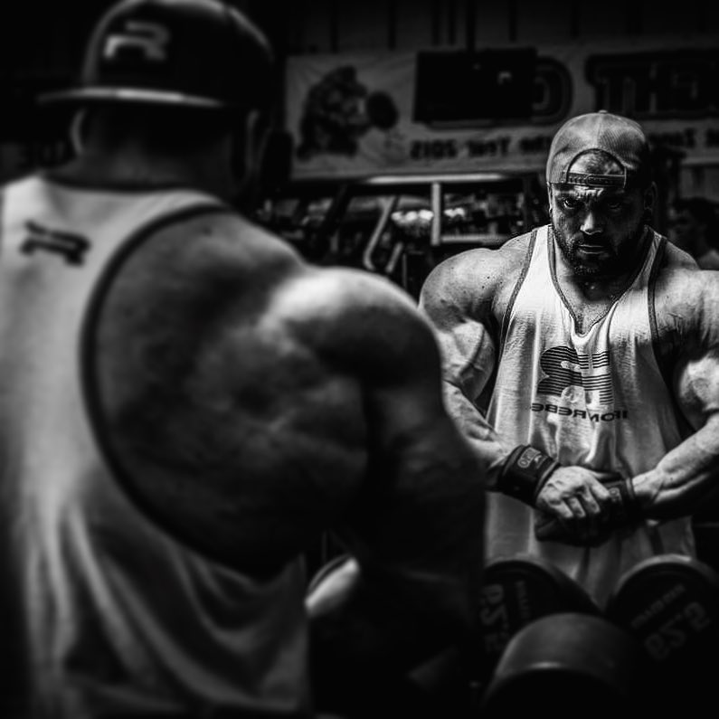 Luke Sandoe flexing in front of a mirror, looking absolutely massive