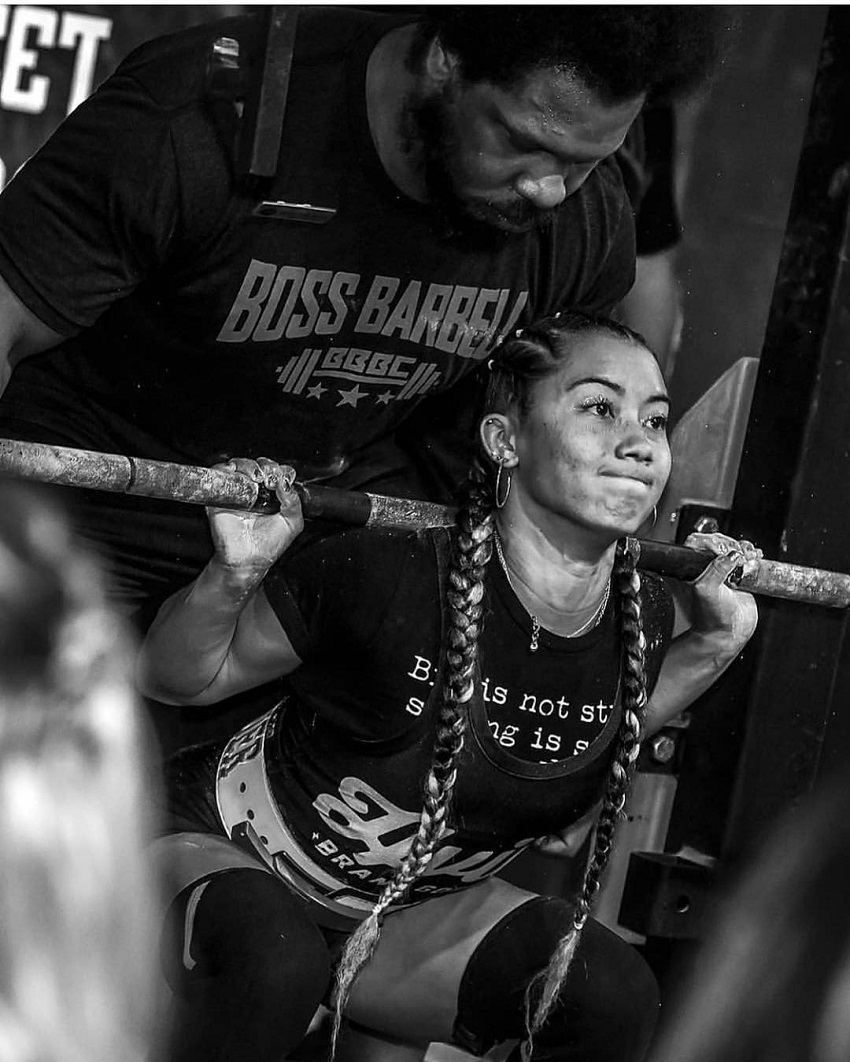 Stacia-Al Mahoe lifting heavy weights during a powerlifting meet