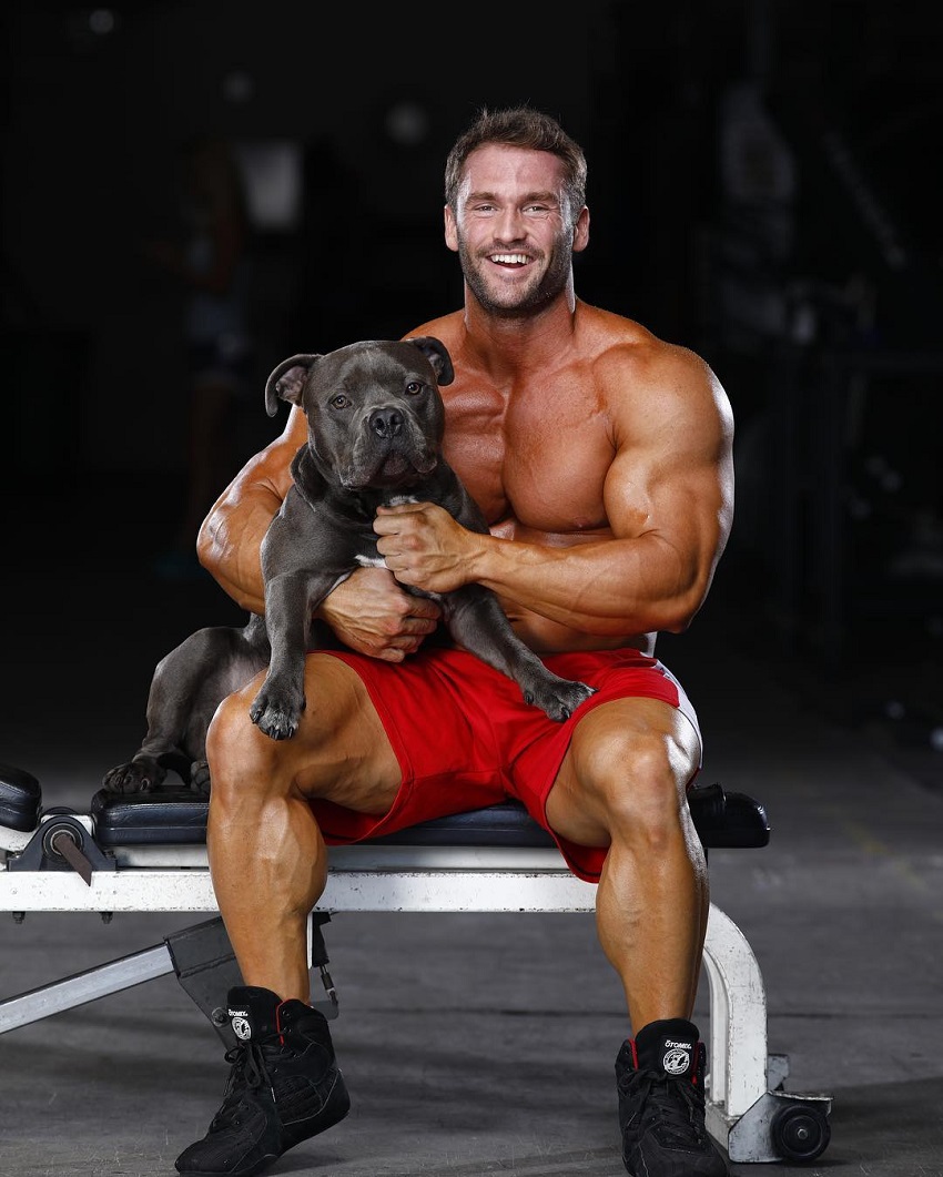 Stanimal De Longeaux posing shirtless with his dog