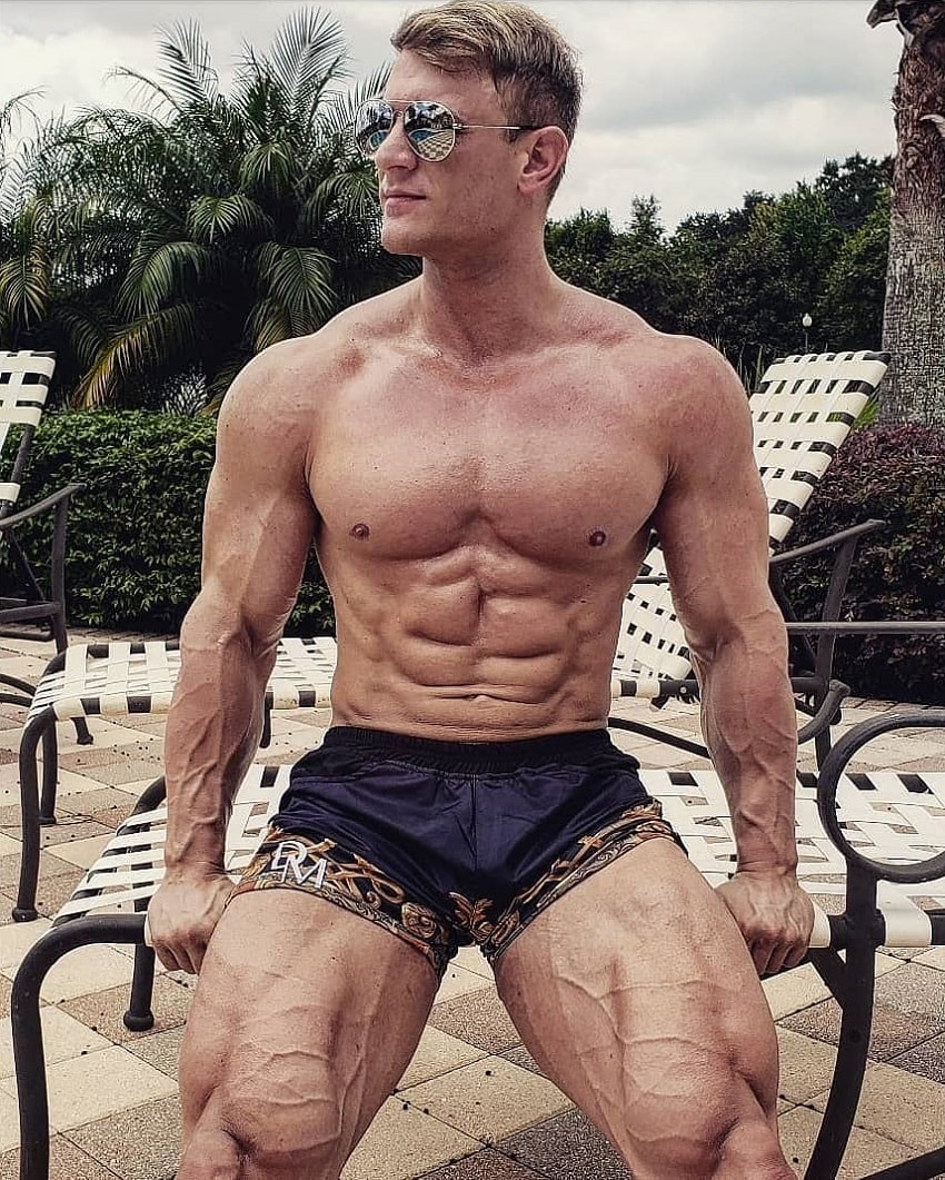 Tyler Garceau posing by a pool looking vascular and ripped