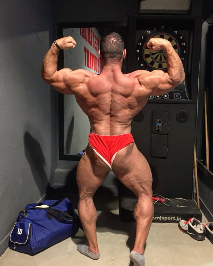 Ayat Bagheri doing a back double biceps flex, practicing posing in front of the camera
