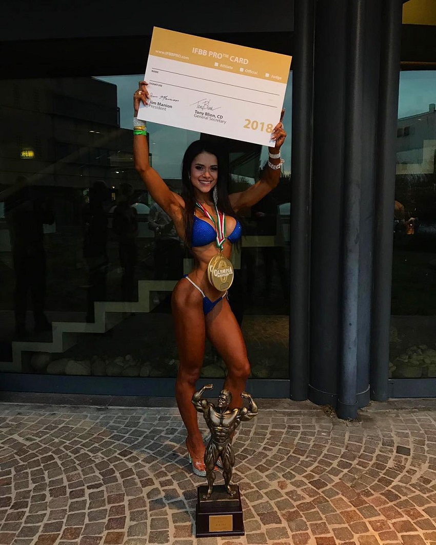 Beatriz Biscaia posing with her IFBB Pro Fitness Card