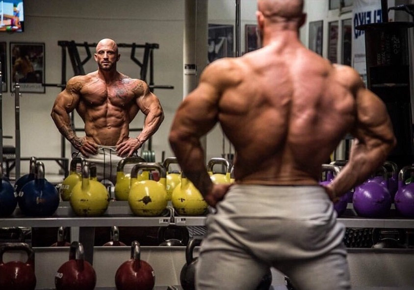 Benjamin Radic flexing shirtless in front of a mirror