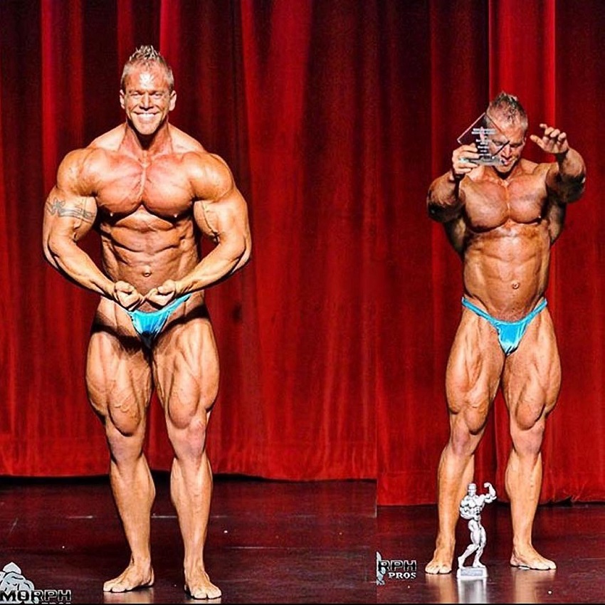 Brandon Beckrich posing with a trophy on a bodybuilding stage