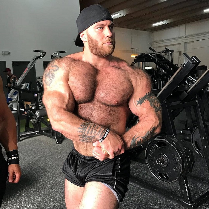 Caleb Blanchard performing a side chest pose in a gym
