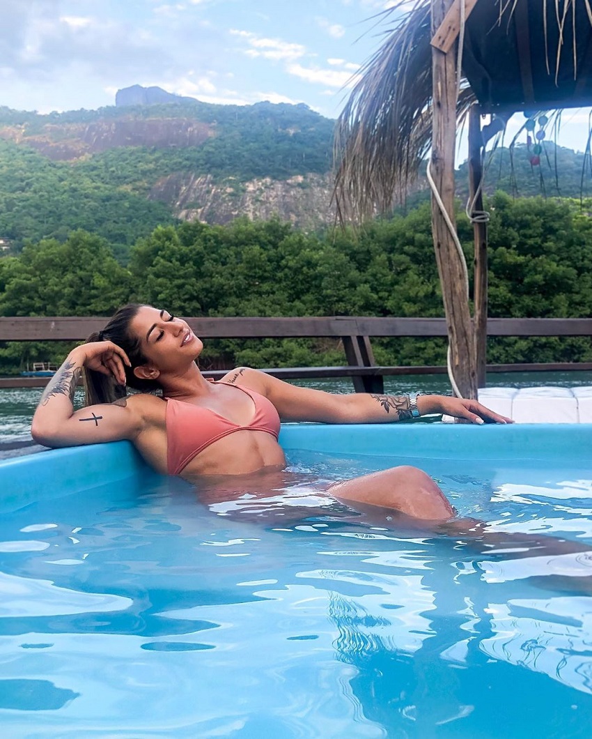 Dominique Aquino lying in a pool with a beautiful view