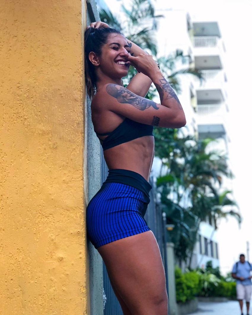 Dominique Aquino leaning against a wall and smiling