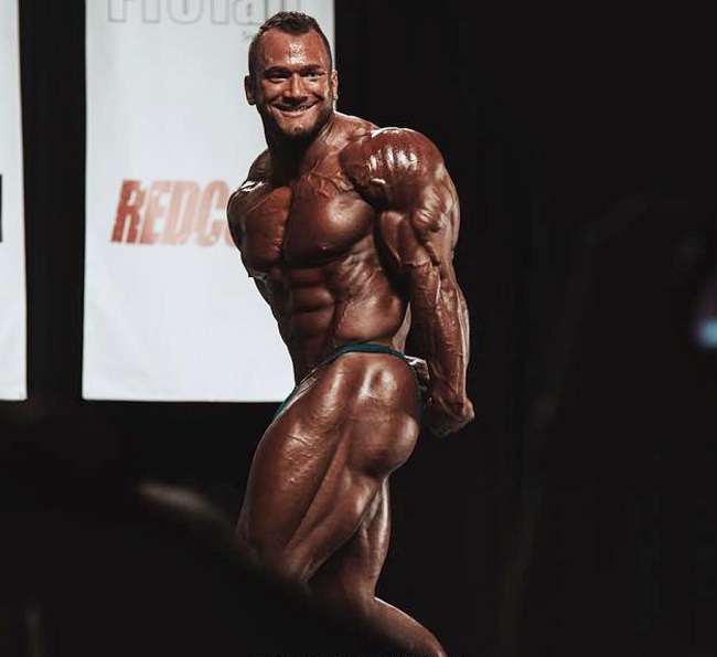 Hunter Labrada doing a side triceps pose on a bodybuilding stage