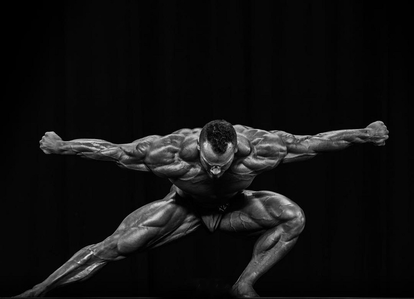 Hunter Labrada posing on a bodybuilding stage looking gigantic and ripped