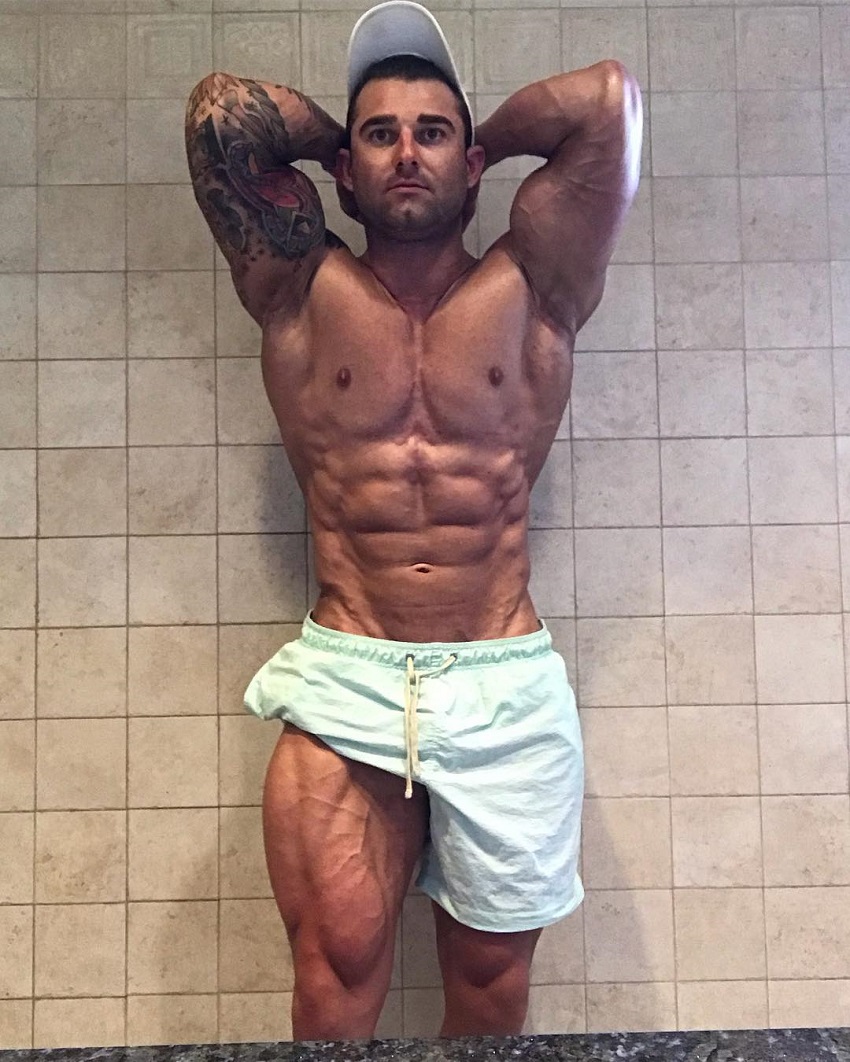 Jase Stevens flexing his abs while shirtless, looking ripped