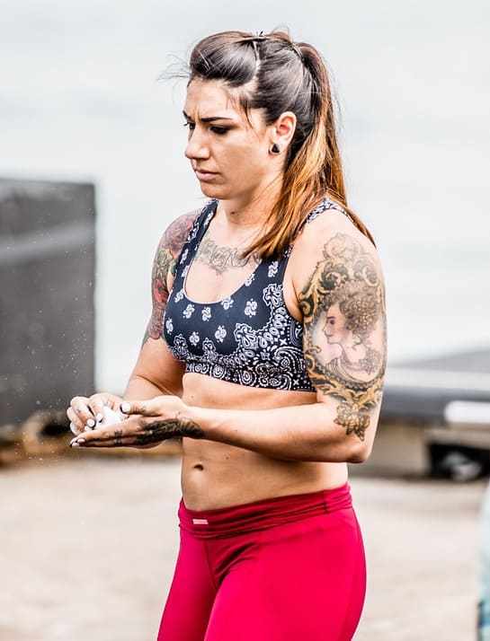 Kat Leone rubbing chalk into her hands during a crossfit event