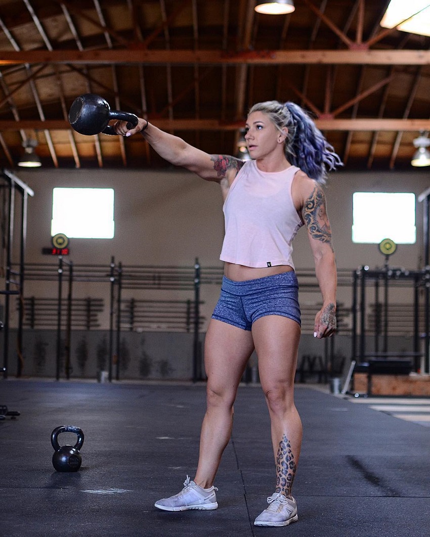 Kat Leone performing kettlebell swings in a crossfit gym